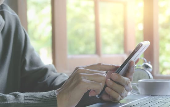 Hand holding and using a smart phone. Technology and communication concept.