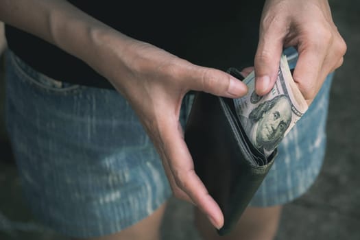 Hand holding a banknote in wallet for financial, accounting and saving money concept.