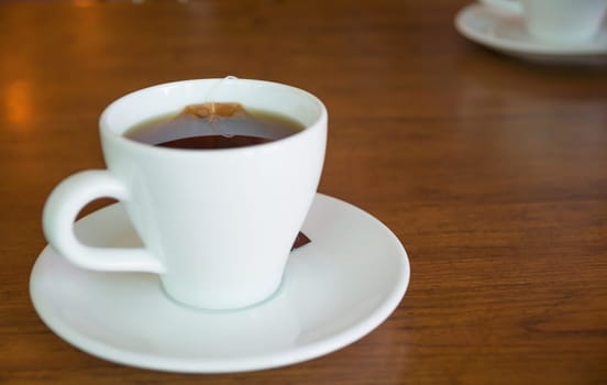 Closeup of hot tea cup on a wooden table and copy space.