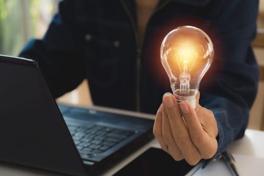 Hand of male holding a light bulb for innovation and creative concept .