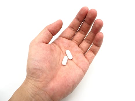 Hand holding a white pills isolated on white background.