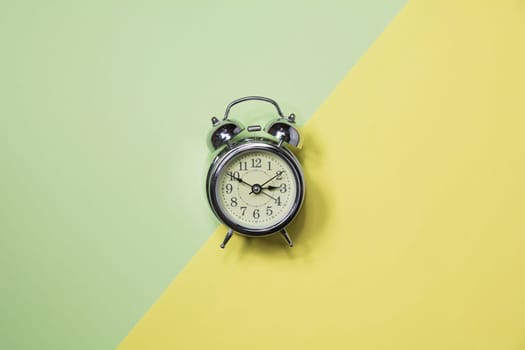Top view of alarm clock on colorful background and copy space for insert text.