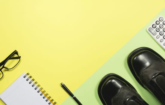 White blank notebook with office supplies on yellow background with copy space for insert text.