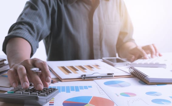 Person working and using a calculator for financial and accounting concept.