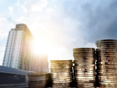 Money coin stack with on blurred building background. Financial and accounting concept.