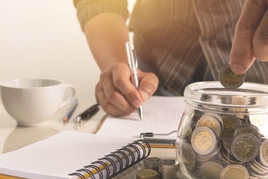 Businessman working and writing on notebook for business with financial and accounting concept.