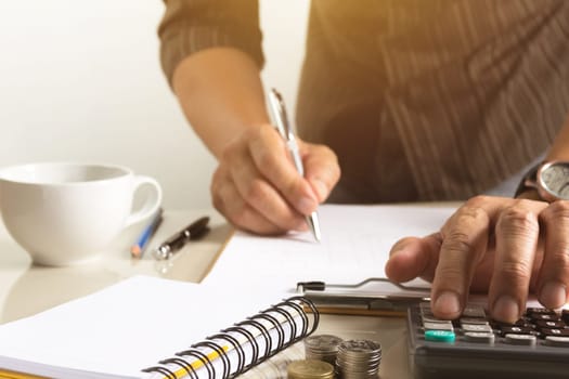 Businessman working and writing on notebook for business with financial and accounting concept.