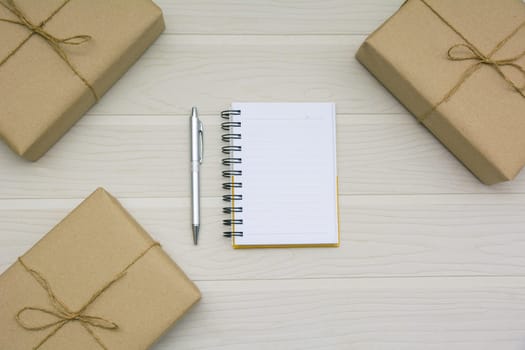 Top view of open book. Book open with pen and boxes on wooden background and copy space for insert text.