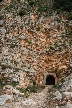 Entrance to the tunnel cut out inside the rock on the coastal walking path in Petrovac, Montenegro