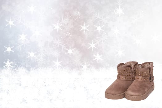 Winter background. Christmas winter background with new brown winter boots on wooden snowy board over abstract white festive xmas background. Space for your product display montage.