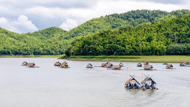 Bamboo raft shelter are floating restaurant in the middle of water under the blue sky as a tourist attraction at Huai Krathing Reservoir, Loei province, Thailand, 16:9 widescreen