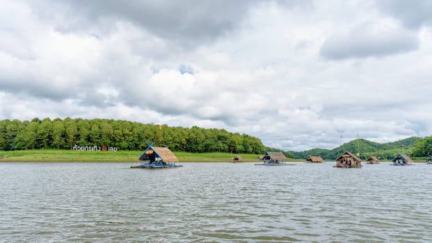 Bamboo raft shelter are floating restaurant in the middle of water under the blue sky as a tourist attraction at Huai Krathing Reservoir, Loei province, Thailand, 16:9 widescreen
