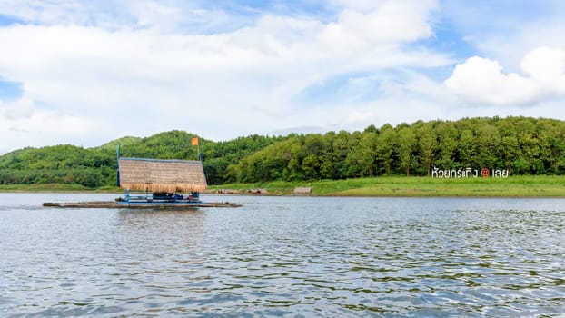 Place nameplate of Huai Krathing and bamboo raft shelter are floating restaurant in the middle of water under the blue sky as a tourist attraction of Loei province,Thailand, 16:9 widescreen