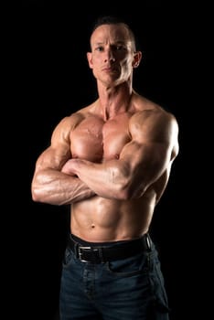 Power athletic man with great physique. Strong bodybuilder showing perfect body isolated in black.
