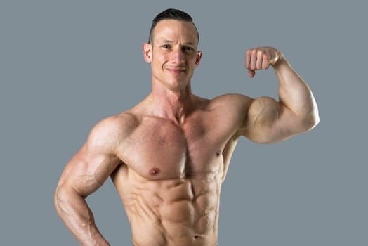Powerful athletic man with great physique. Strong bodybuilder showing his biceps.