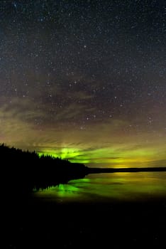 Northern Lights over Lake with clouds and stars.