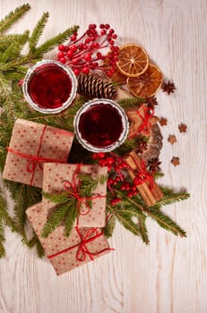 Still life with glasses of mulled wine or fruit tea, gift boxes, gingerbread cookies and christmas decorations on a wooden table.Top view. Christmas and New Year treat.