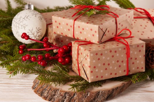 Still life with gift boxes, fir tree branches and christmas decorations on a wooden table. Christmas and New Year