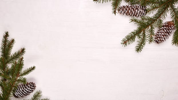 White wooden background with fir branches and cones. New Year and Christmas