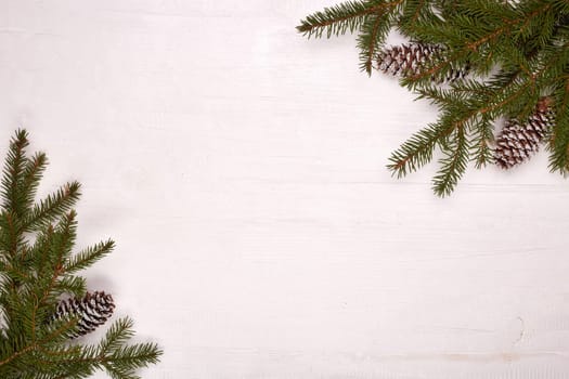 White wooden background with fir branches and cones. New Year and Christmas