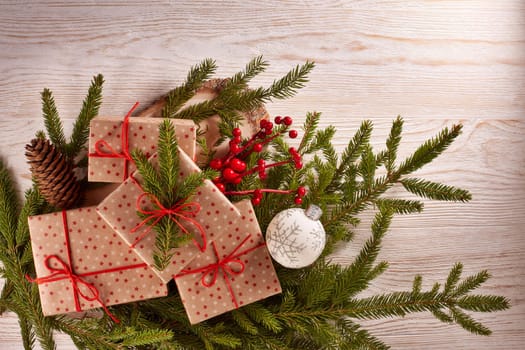 Still life with gift boxes, fir tree branches and christmas decorations on a wooden background.Top view with copy space. Christmas and New Year