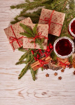 Still life with glasses of mulled wine or fruit tea, gift boxes, gingerbread cookies and christmas decorations on a wooden table.Top view. Christmas and New Year treat.