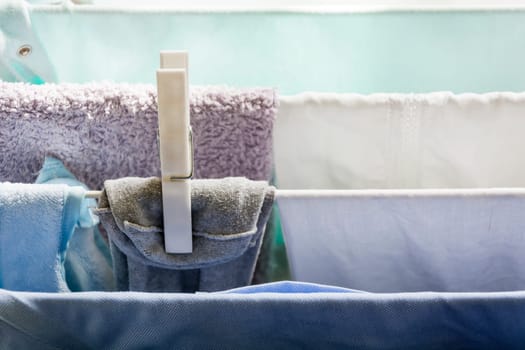 Laundry on a clothesline drying with a white plastic peg