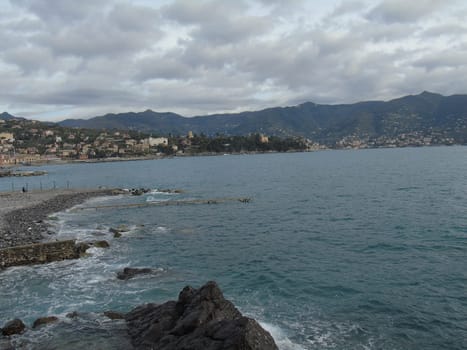 An amazing caption of the beautiful places from the 5 Terre in Liguria with an amazing blue sky and some green mountains in the background
