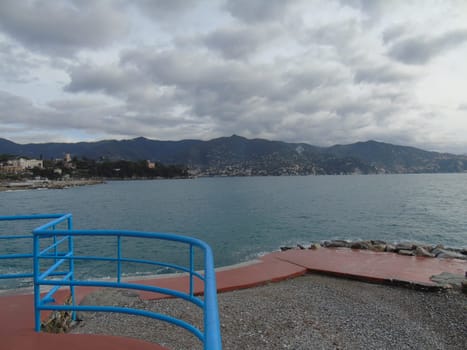 An amazing caption of the beautiful places from the 5 Terre in Liguria with an amazing blue sky and some green mountains in the background