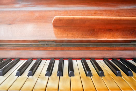 Keyboard of a well worn piano. Frontal view