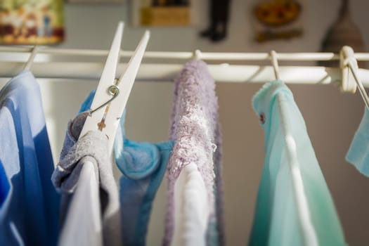 Close up of a white plastic clothespin on a clotheshorse with laundry drying