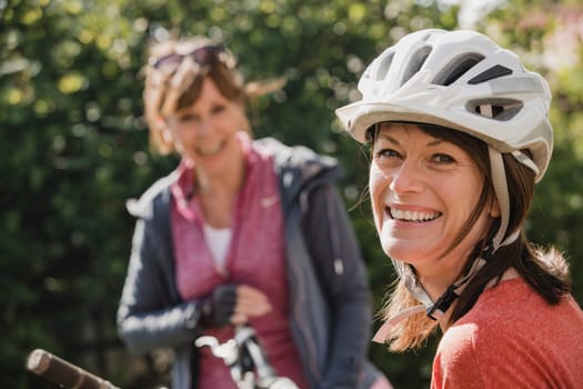 Headshot of a mature female wearing a cycling helmet and looking at the camera and smiling.