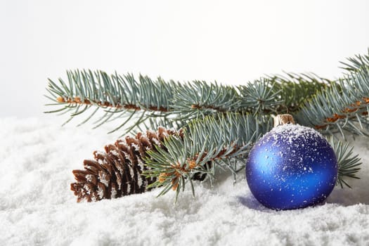 Winter snow background with fir tree branch, cone and christmas decoration. New Year and Christmas