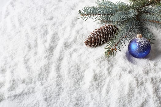 Winter snow background with fir tree branch, cone and christmas decoration. New Year and Christmas