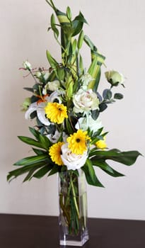 Beautiful colorful flowers in a vase on a background wall