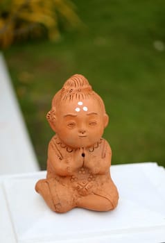 Statue of a young child in a pose of praying Buddha
