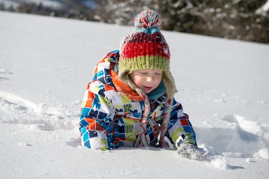 little 3 year old child playing in the snow