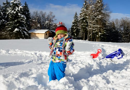 little 3 year old child playing in the snow