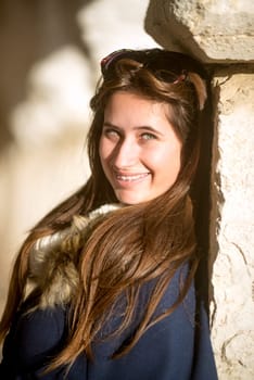 Beautiful happy young girl posing outdoors near old building