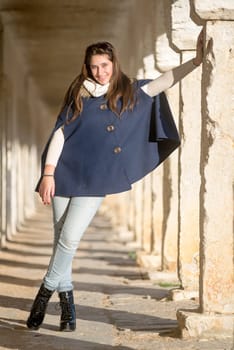 Beautiful happy young girl posing outdoors near old building