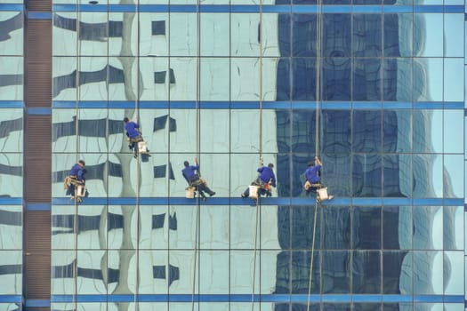 Workers cleaning windows service on high rise building