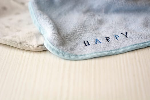 a baby bib with the word "HAPPY"" resting on a white table"