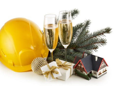 Construction hard hat, fir tree branches, model house, two glasses with champange and Christmas ornament isolated on a white background. New Year and Christmas. Horizontal view