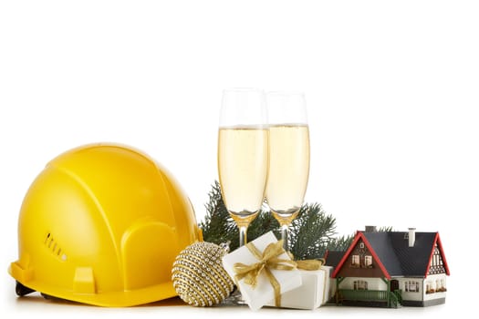 Construction hard hat, fir tree branches, model house, two glasses with champange and Christmas ornament isolated on a white background. New Year and Christmas. Horizontal view with copy space