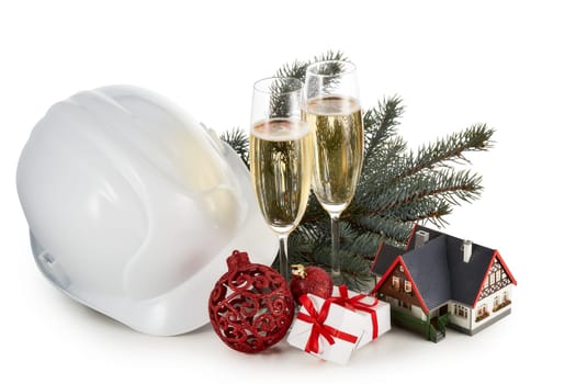 Construction hard hat, fir tree branches, model house, two glasses with champange and Christmas ornament isolated on a white background. New Year and Christmas. Horizontal view