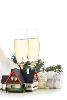 Construction hard hat, fir tree branches, model house, two glasses with champange and Christmas ornament isolated on a white background with clipping path. New Year and Christmas.