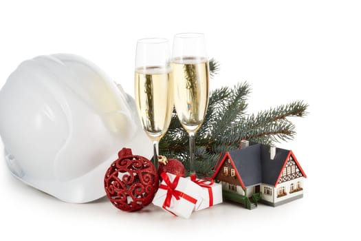 Construction hard hat, fir tree branches, model house, two glasses with champange and Christmas ornament isolated on a white background. New Year and Christmas. Horizontal view