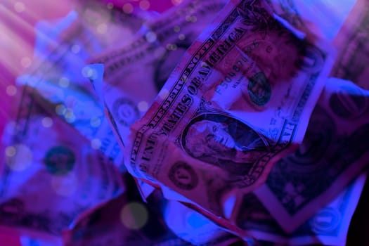 close up wrinkled American one dollar bills under colorful lights