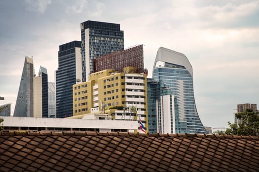 cityscape of modern architecture buildings over moody sky in downtown Bangkok, Thailand