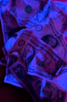 close up wrinkled American one dollar bills under colorful lights